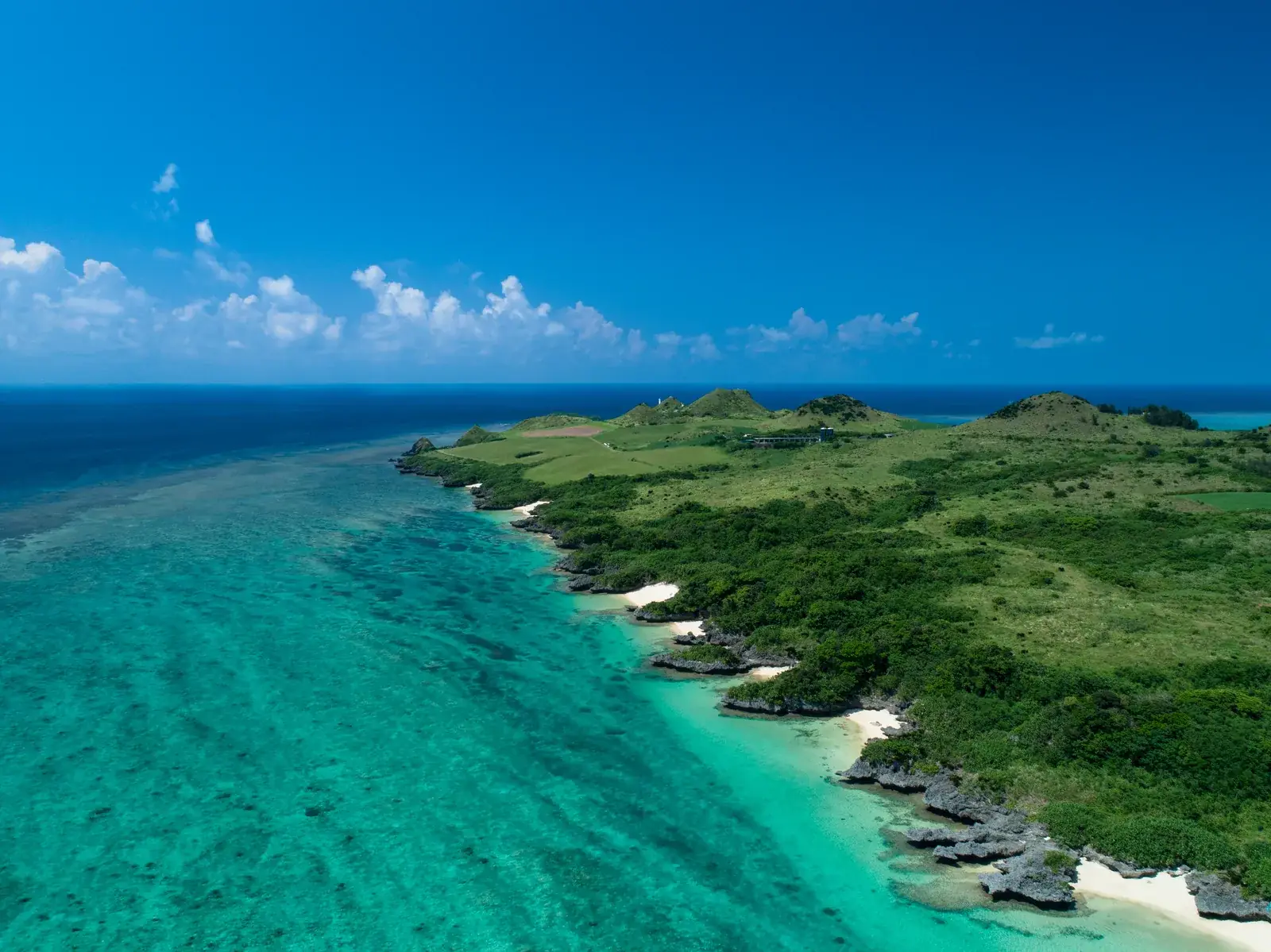 Aerial view of the green northern coast of Ishigaki and its turquoise sea