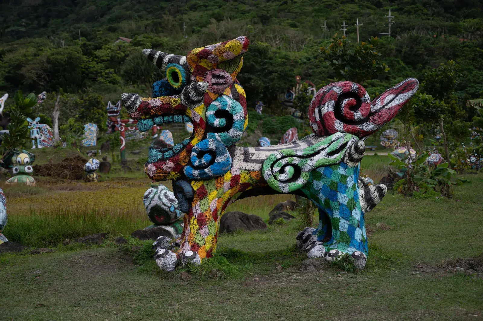 Colourful shisa figures in a green garden on Ishigaki