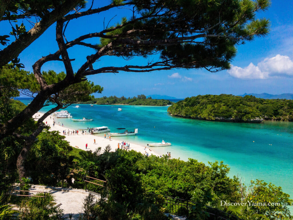 Kabira Bay Ishigaki with glass-bottom boats on emerald green water.