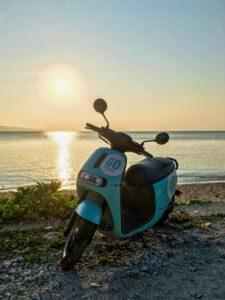 Scooter on a coastal road in Ishigaki Island with ocean in the background.