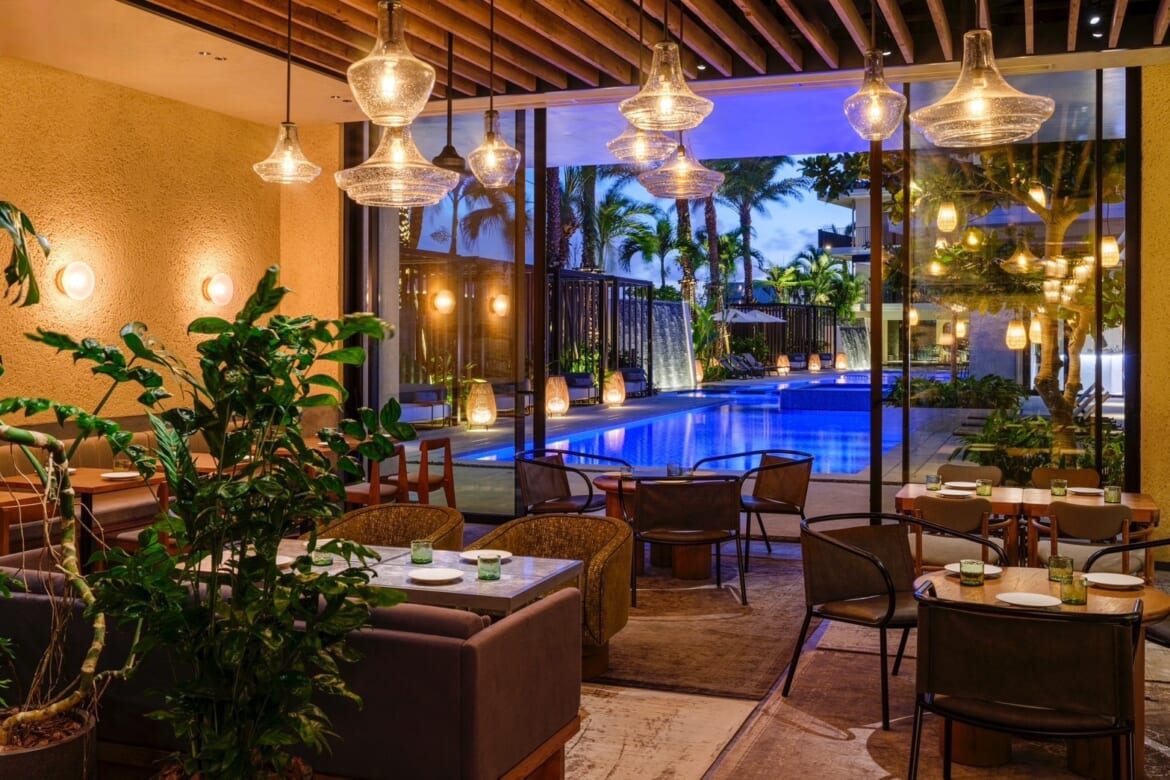 Dining table at Batida restaurant on Ishigaki Island with a view of the 7x7 Hotel swimming pool.
